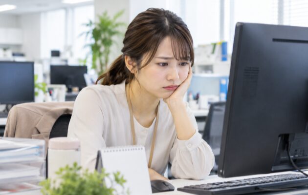 派遣で働くもなかなか時給が上がらずに悩んでいるオフィスの女性